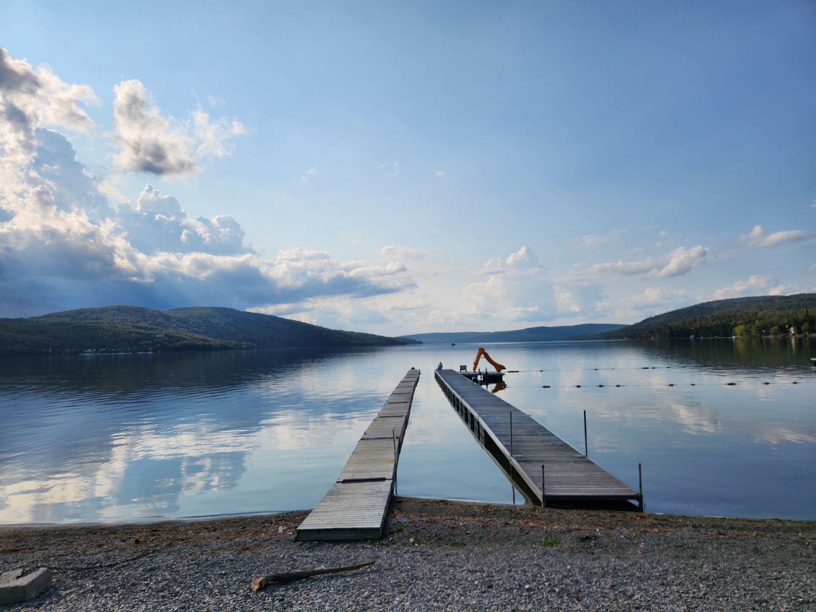 Un quai flottant sur la rive d'un lac bordé de montagnes
